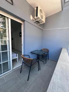a patio with a table and chairs and a heater at Olympus Apartments in Paralia Katerinis