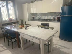 a kitchen with a table with chairs and a blue refrigerator at Villa Alessandra in Acqui Terme +7 photos