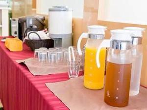 a table with two bottles of orange juice and glasses at Saga Idaimae Green Hotel in Saga