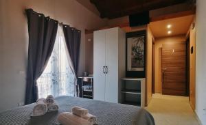 a bedroom with a bed and a window with towels on it at B&B Villa Marsico in Falerna