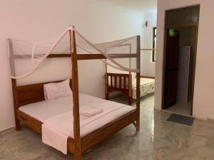 a bedroom with a bunk bed with a mosquito net at CAAA Youth Hostel in Kibanguni