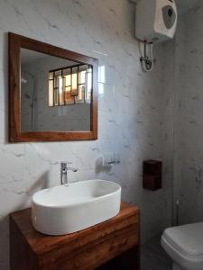 a white bathroom with a sink and a mirror at Moshi hostel lodge in Msaranga +75 photos