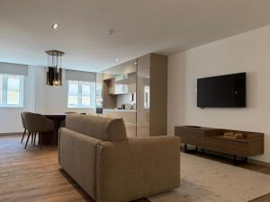 a living room with a couch and a table and a television at Apartamento do Teatro in Lamego