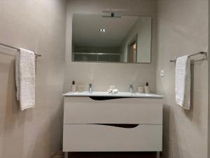 a bathroom with a white sink and a mirror at Apartamento do Teatro in Lamego +14 photos