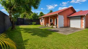 a house with a red roof and a yard at La Kaz' Mathosie in Saint-André