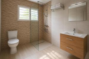 a bathroom with a toilet and a sink and a shower at La Kaz' Mathosie in Saint-André