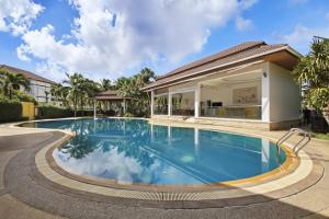 a swimming pool in front of a house at Rawai Grand House -SHA Plus in Rawai Beach