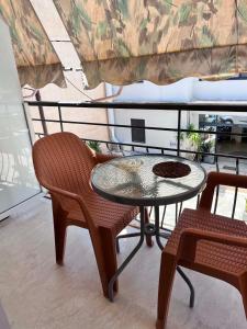a glass table and two chairs on a balcony at Studios Μιχαλαρεα in Kyparissia