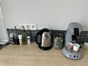 a kitchen counter with a coffee maker and cups at Maison tout confort in Corbie +23 photos