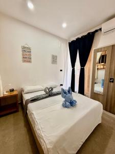 a blue teddy bear sitting on top of a bed at Hero House in Pooc +40 photos