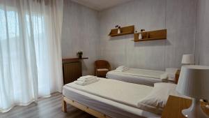 a room with two beds and a window at MAGIA - Tra Laghi e Montagne in Gravellona Toce
