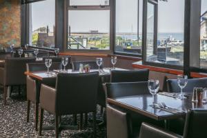 a restaurant with tables and chairs and windows at Best Western Lancaster Morecambe Lothersdale Hotel in Morecambe