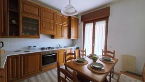 a kitchen with a wooden table with chairs and a dining room at MAGIA - Tra Laghi e Montagne in Gravellona Toce +3 photos