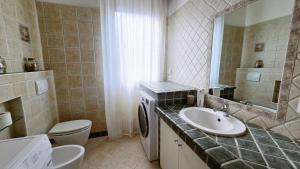 a bathroom with a sink and a toilet and a mirror at MAGIA - Tra Laghi e Montagne in Gravellona Toce