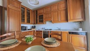a kitchen with wooden cabinets and a wooden table at MAGIA - Tra Laghi e Montagne in Gravellona Toce