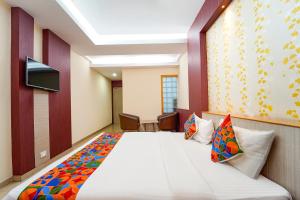a hotel room with a bed and a tv at FabHotel Grand Gunas in Coimbatore