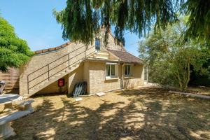 a house with a staircase on the side of it at Gite de Puisaye in Breteau