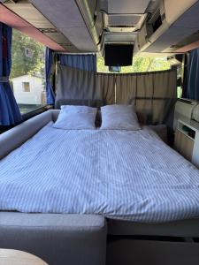 a bed in the back of a camper van at Unique et Insolite Bus Iliade in Bourg +38 photos