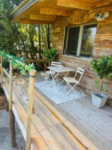 a wooden deck with a table and chairs on it at Les Lodges de l'Etang in Roquebrune-sur-Argens +11 photos