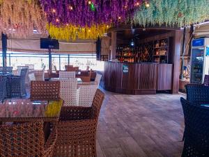 a restaurant with tables and chairs and a bar at Joebrown Palace Hotel & Suite in Akitan