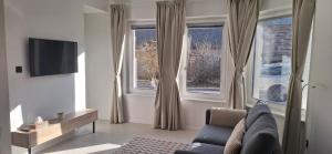 a living room with a couch and two windows at River2Mountain Cozy Apartment in Gozd Martuljek