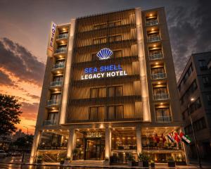 a building with a sea shell legacy hotel at dusk at Seashell Legacy Hotel in Karachi