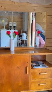 a wooden cabinet with red flowers on top of it at Pikku aitta in Heikkilä