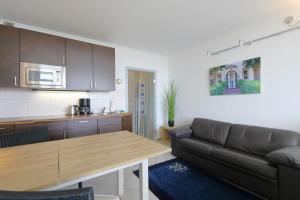 a living room with a couch and a table at Weber19 - Haus Hammerich in Wenningstedt