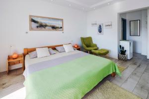 a bedroom with a green bed and a green chair at SUPER HORIZONT- Sea View Apartments with private Jacuzzi time & Free Parking in Split +107 photos