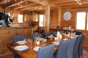 a dining room with a table and chairs and a clock at Chalet Le Plan des Rochers in Morzine