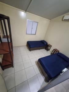 a small room with a bed and a window at Condomínio Gold in Três Lagoas