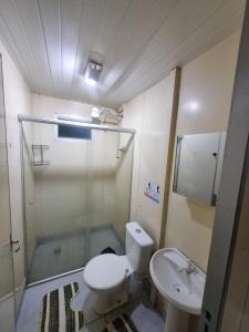 a bathroom with a toilet and a sink at Condomínio Gold in Três Lagoas