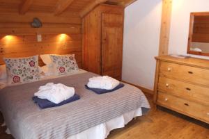 a bedroom with a bed with towels on it at Chalet Le Plan des Rochers in Morzine