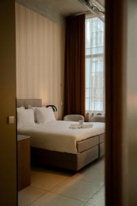 a bedroom with a bed and a large window at WestCord Hotel Eindhoven in Eindhoven