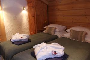 two beds in a room with towels on them at Chalet Le Plan des Rochers in Morzine