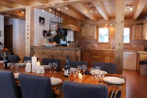 a dining room table with chairs and wine glasses at Chalet Le Plan des Rochers in Morzine