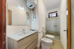 a white bathroom with a sink and a toilet at Casa Margherita in Forno +15 photos