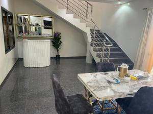 a dining room with a table and chairs and stairs at RESIDENCE Diass Immo in Diass
