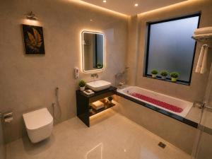 a bathroom with a tub and a toilet and a sink at Hotel KS Palace in Varanasi +9 photos