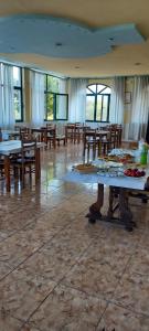 a large room with tables and chairs and windows at Agron S in Vlorë +12 photos