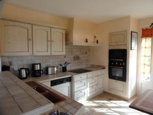 a kitchen with white cabinets and a stove top oven at Gite Du Moulin De Veyriat in Lescheroux +19 photos
