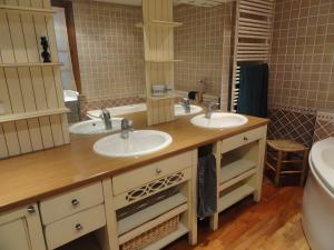 a bathroom with two sinks and a large mirror at Gite Du Moulin De Veyriat in Lescheroux