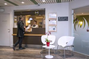 a man is standing in front of a cash register at B&B HOTEL La Rochelle Centre in La Rochelle