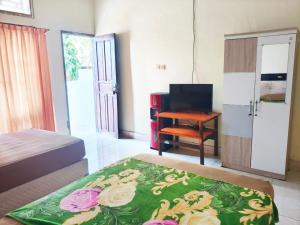 a bedroom with a bed and a desk and a table at Nangas Homestayy in Huu