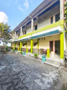 a building with yellow and green paint on it at Nangas Homestayy in Huu