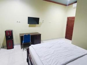 a bedroom with a bed and a desk and a tv at Nangas Homestayy in Huu +5 photos