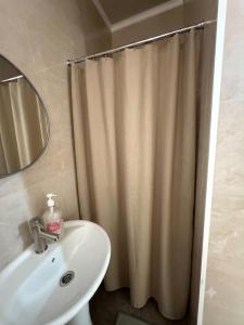 a bathroom with a shower curtain and a sink at Kaganat village in Uchar +20 photos