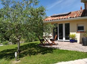 a house with a table and chairs in the yard at Studio cosy avec terrasse privée - arrivée autonome in Rouffiac-Tolosan