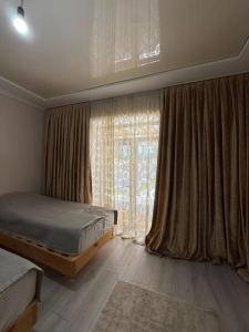 a bedroom with two beds and a large window at Kaganat village in Uchar