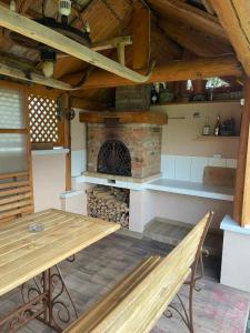 a wooden table and bench in a room with a fireplace at Садиба у Оксани in Verkhneye Sinevidnoye